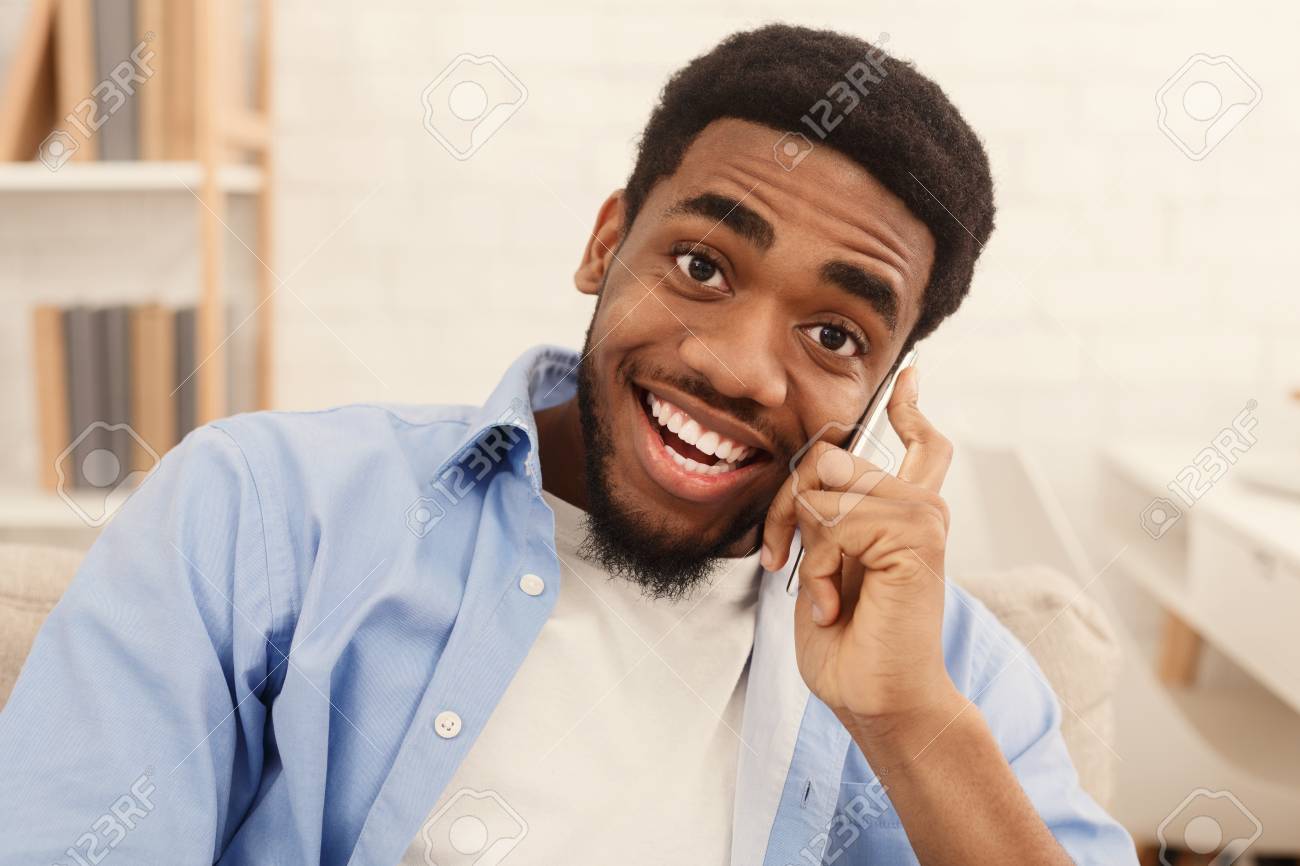 Positive African American Guy Talking On Mobile Phone And Smiling At Camera At Home Free Space Stock Photo Picture And Royalty Free Image Image 120155955