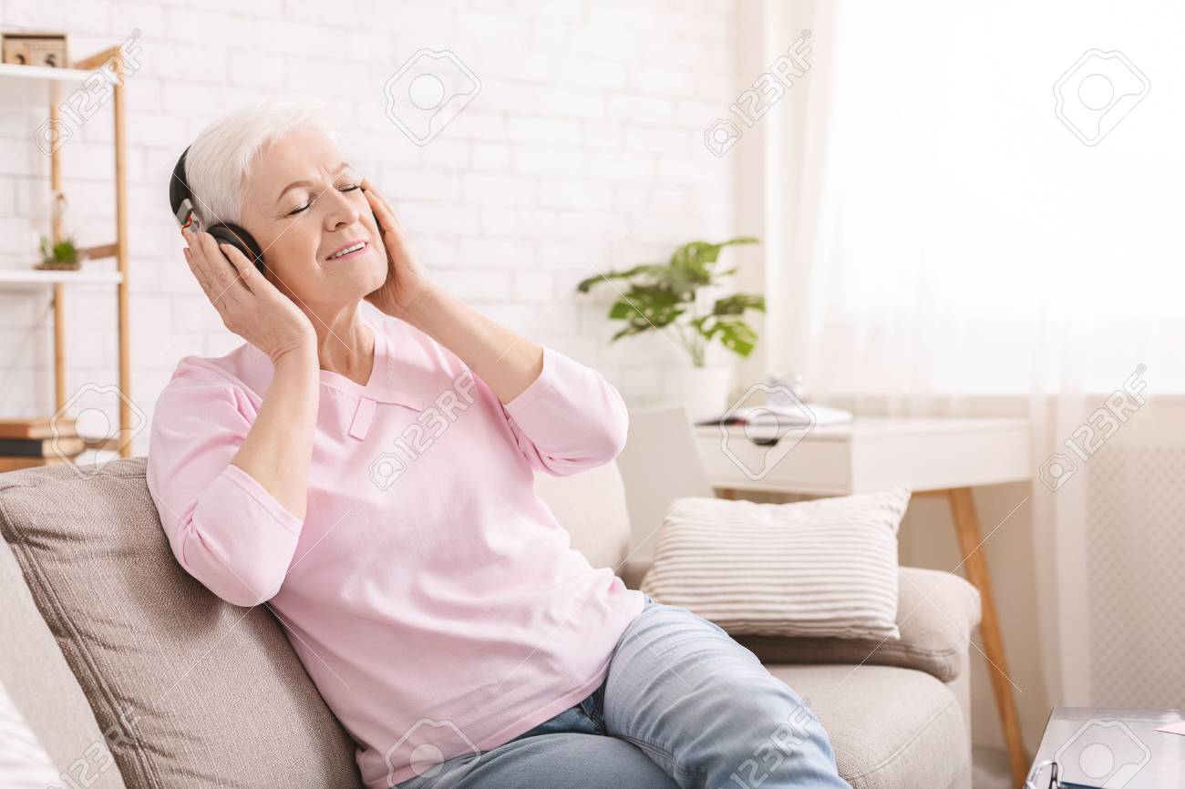 New life of favorite book. Senior woman enjoying audiobook in headphones, free space - 121034948 New life of favorite book. Senior woman enjoying audiobook in headphones, free space - 121034948