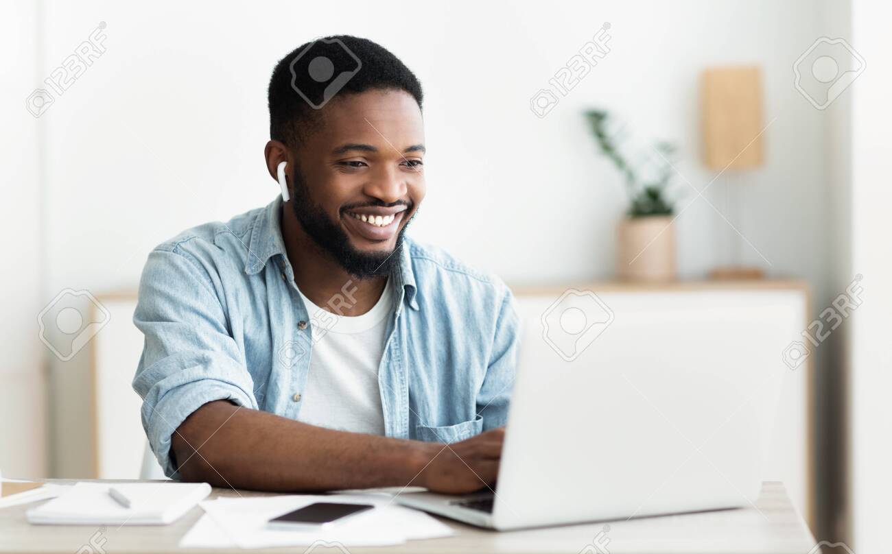 Smiling african-american guy in earphones studying foreign language online through video conference application, panorama with copy space - 128090998 Smiling african-american guy in earphones studying foreign language online through video conference application, panorama with copy space - 128090998