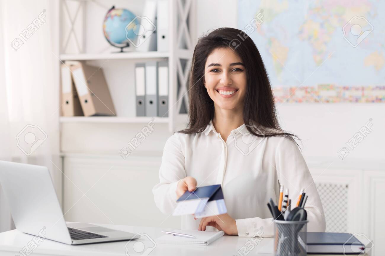female travel agent giving passports with airline tickets for airline agent
