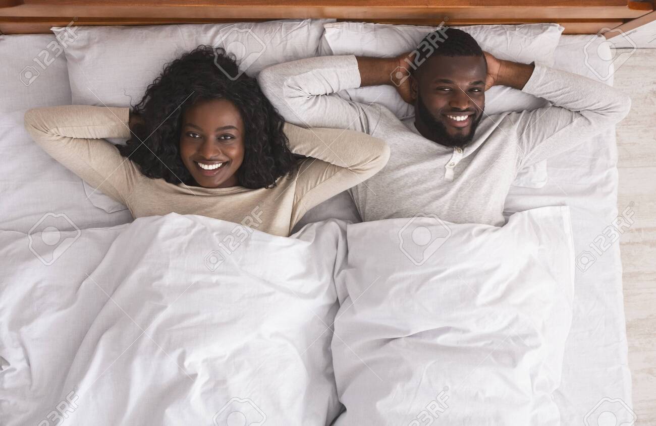 sex後 セックスの後。ベッドで休んで、頭の後ろに手を置いて横たわっている、満足しているアフリカ系アメリカ人のカップル、上面図の写真素材・画像素材 Image  131085026