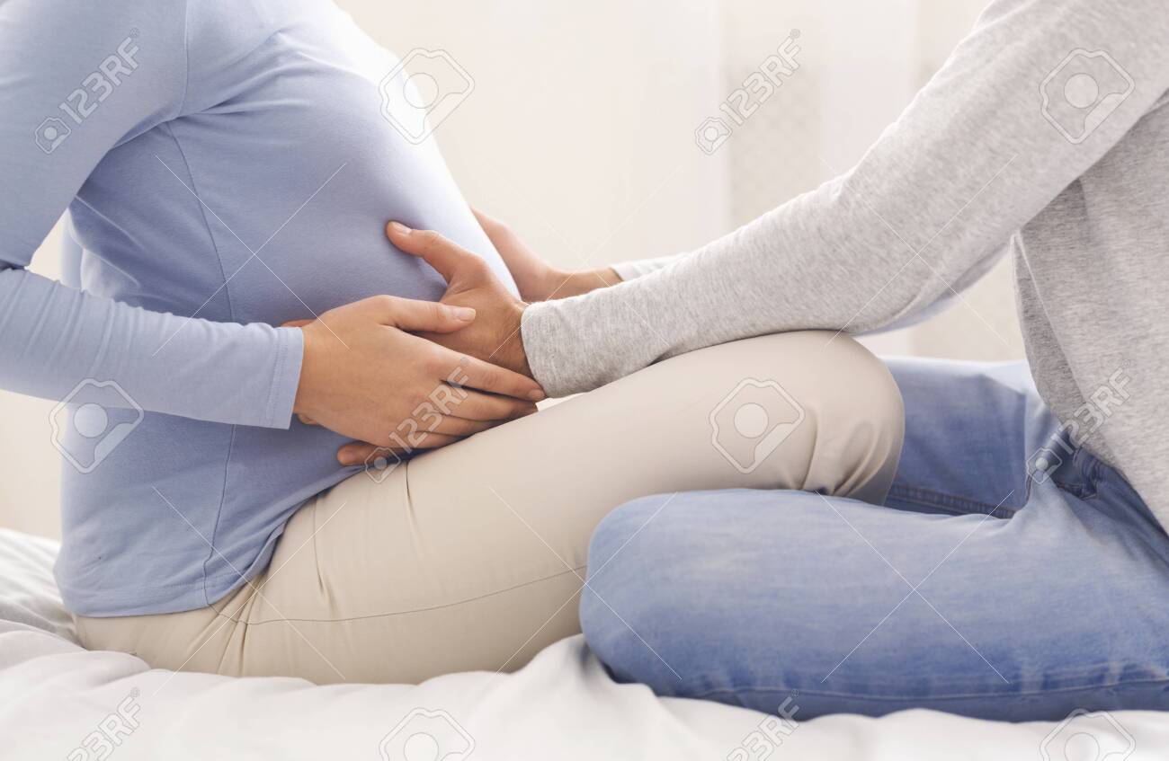 First Baby Kicks Young Couple Sitting On Bed And Touching Pregnant Stock Photo Picture And Royalty Free Image Image 135834083