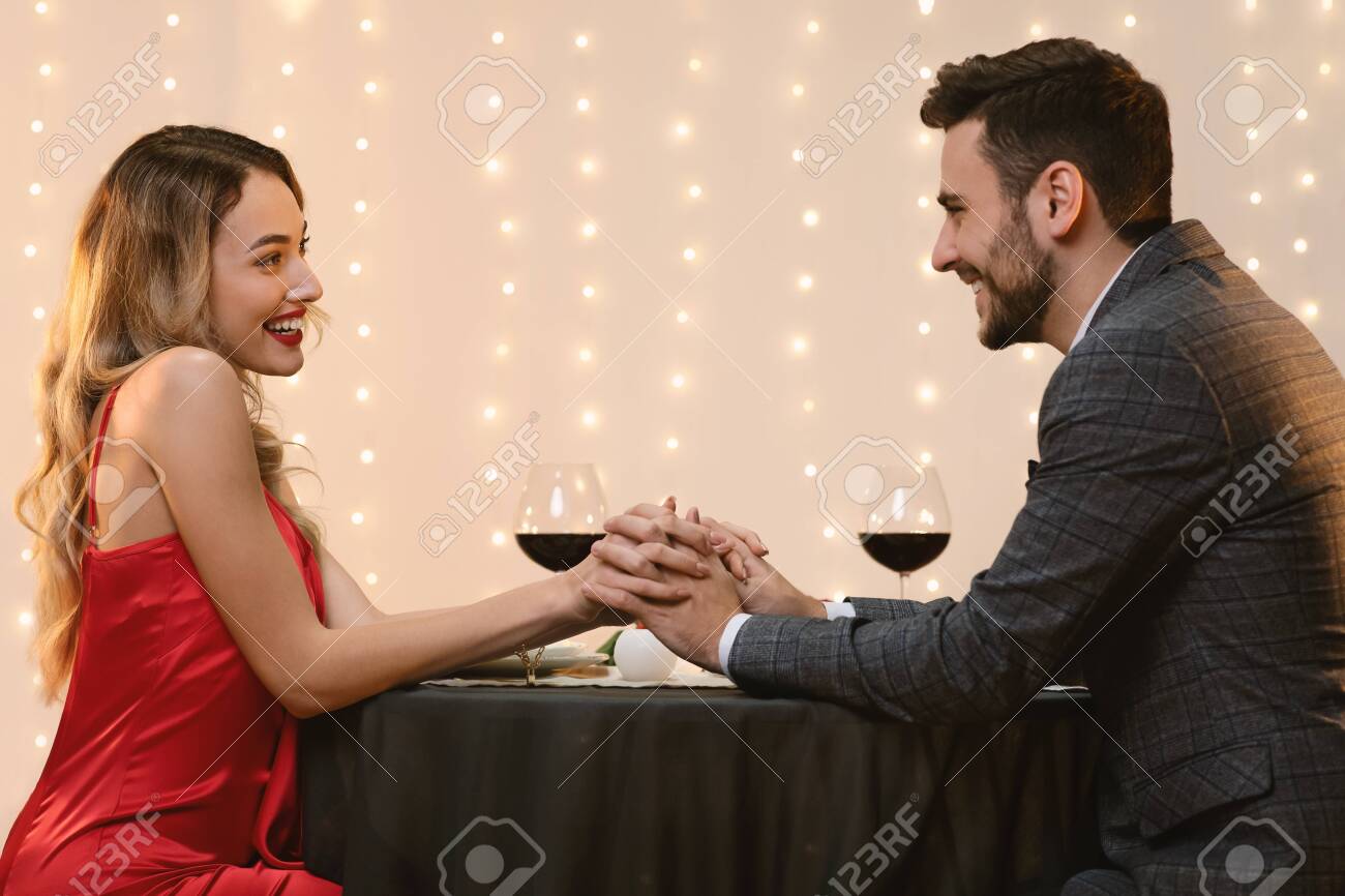 Dream Date Affectionate Couple Holding Hands Bonding Together During Romantic Dinner In Fancy Restaurant Side View Stock Photo Picture And Royalty Free Image Image 140829298