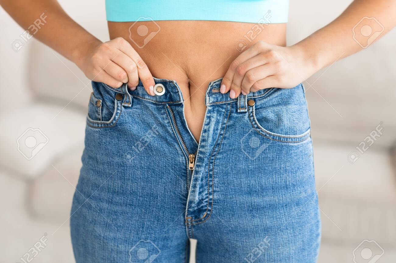 girl putting on tight jeans