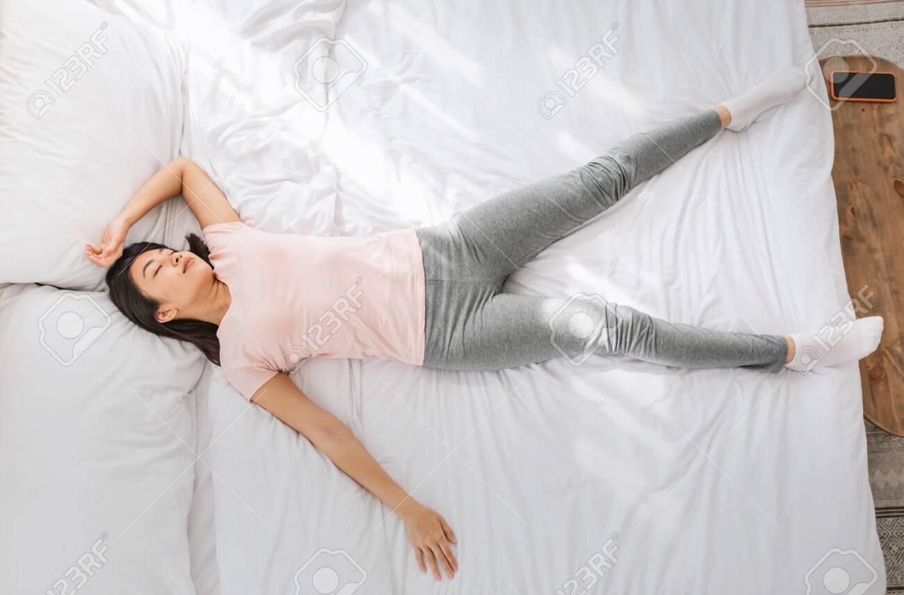 Chinese Girl Sleeping Lying In Funny Pose In Bed Resting And Napping At  Home. Above View Stock Photo, Picture And Royalty Free Image. Image  147346356.