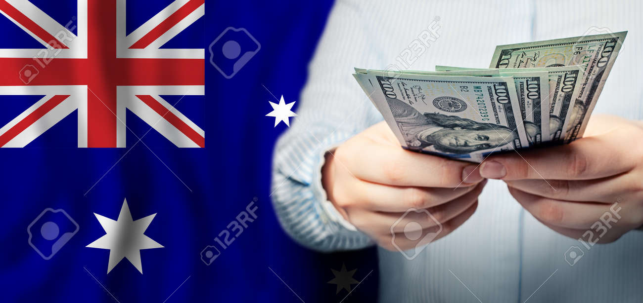Business, Finance And Currency Exchange Concept In Australia. US Dollars  Cash Money In Hand On Australian Flag Background Stock Photo, Picture and  Royalty Free Image. Image 188180987.