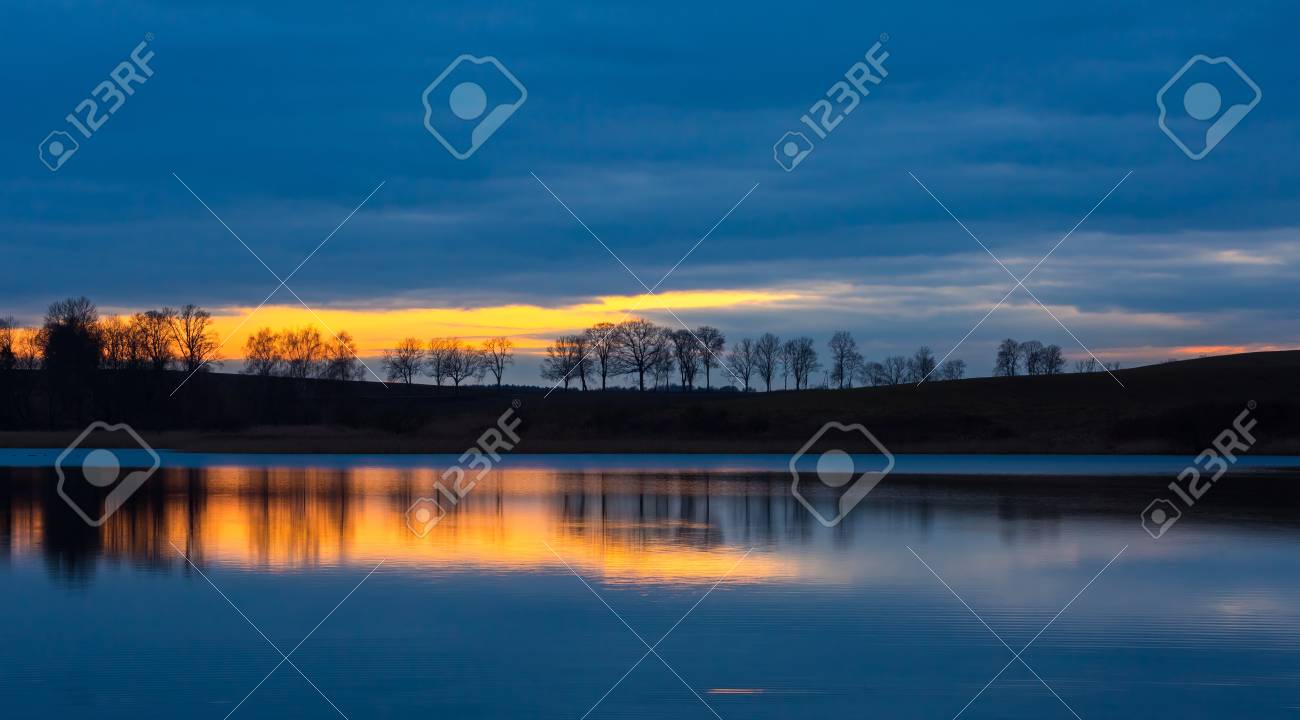 日没の風景後湖 木と水に映った空湖の対岸のクローズ アップ 美しい風景です の写真素材 画像素材 Image