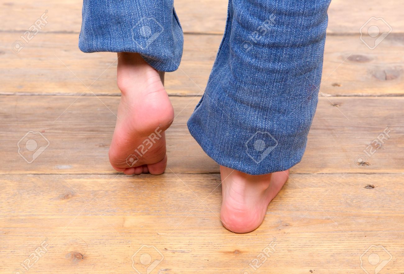Close Up Barefoot Girl Walking On Wooden Floor Stock Photo