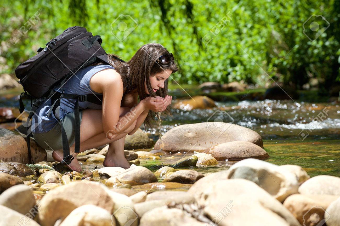 Young woman drinking water from outdoor stream with her hands - 37097775 Young woman drinking water from outdoor stream with her hands - 37097775
