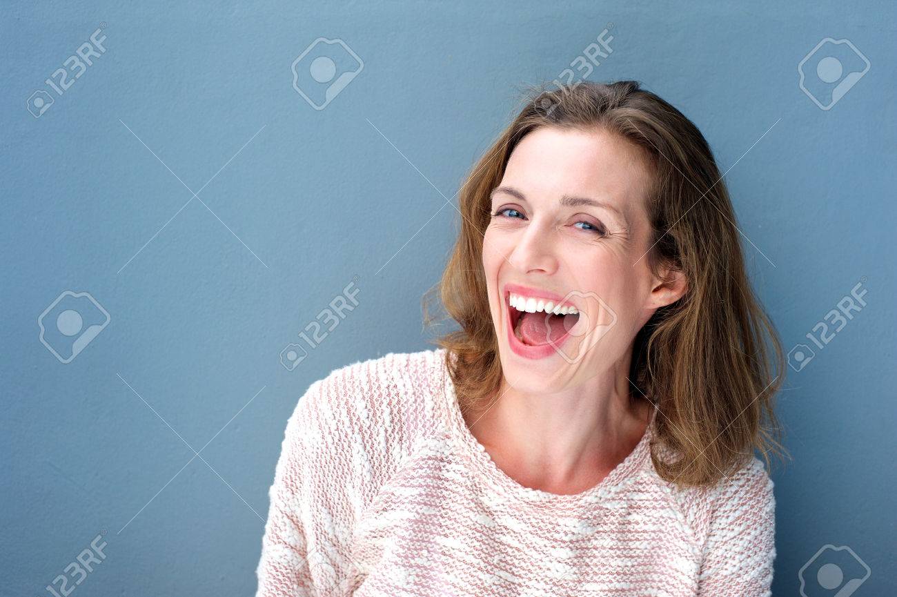 Close up portrait of a happy beautiful fresh mid adult woman laughing on blue background - 37864523 Close up portrait of a happy beautiful fresh mid adult woman laughing on blue background - 37864523