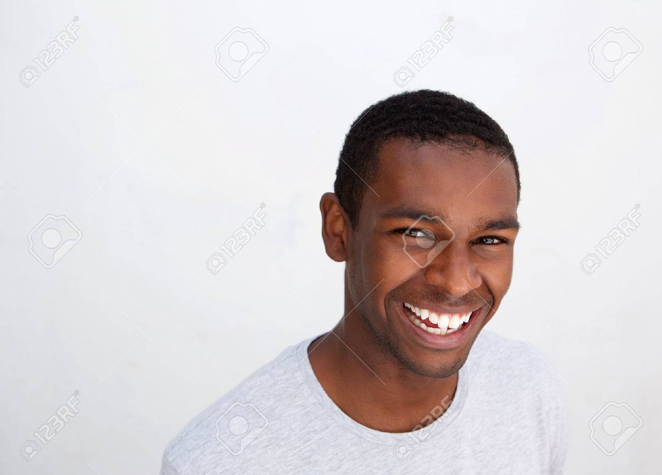 close up portrait of a laughing black guy posing against white