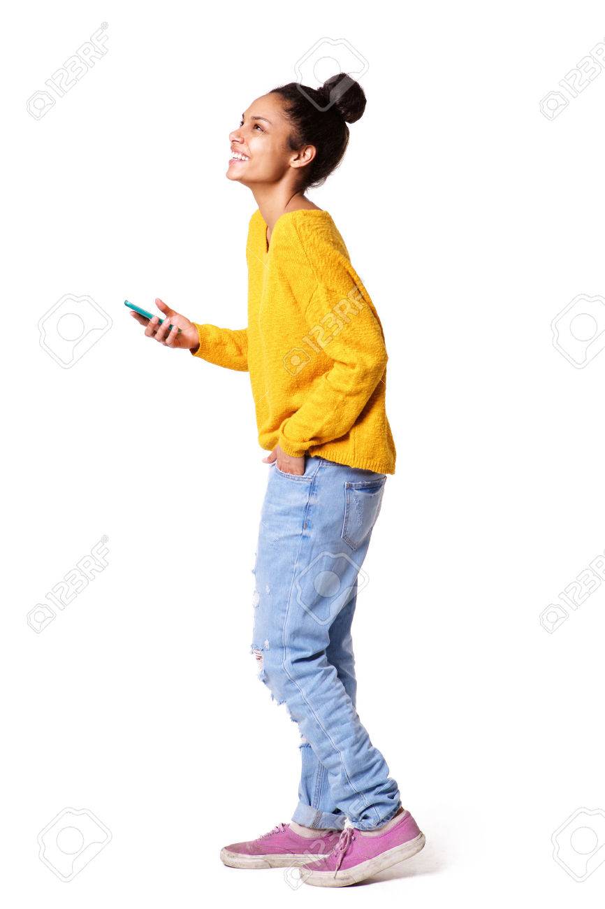 Full body side portrait of african american girl standing with cell phone on white background - 57021766 Full body side portrait of african american girl standing with cell phone on white background - 57021766