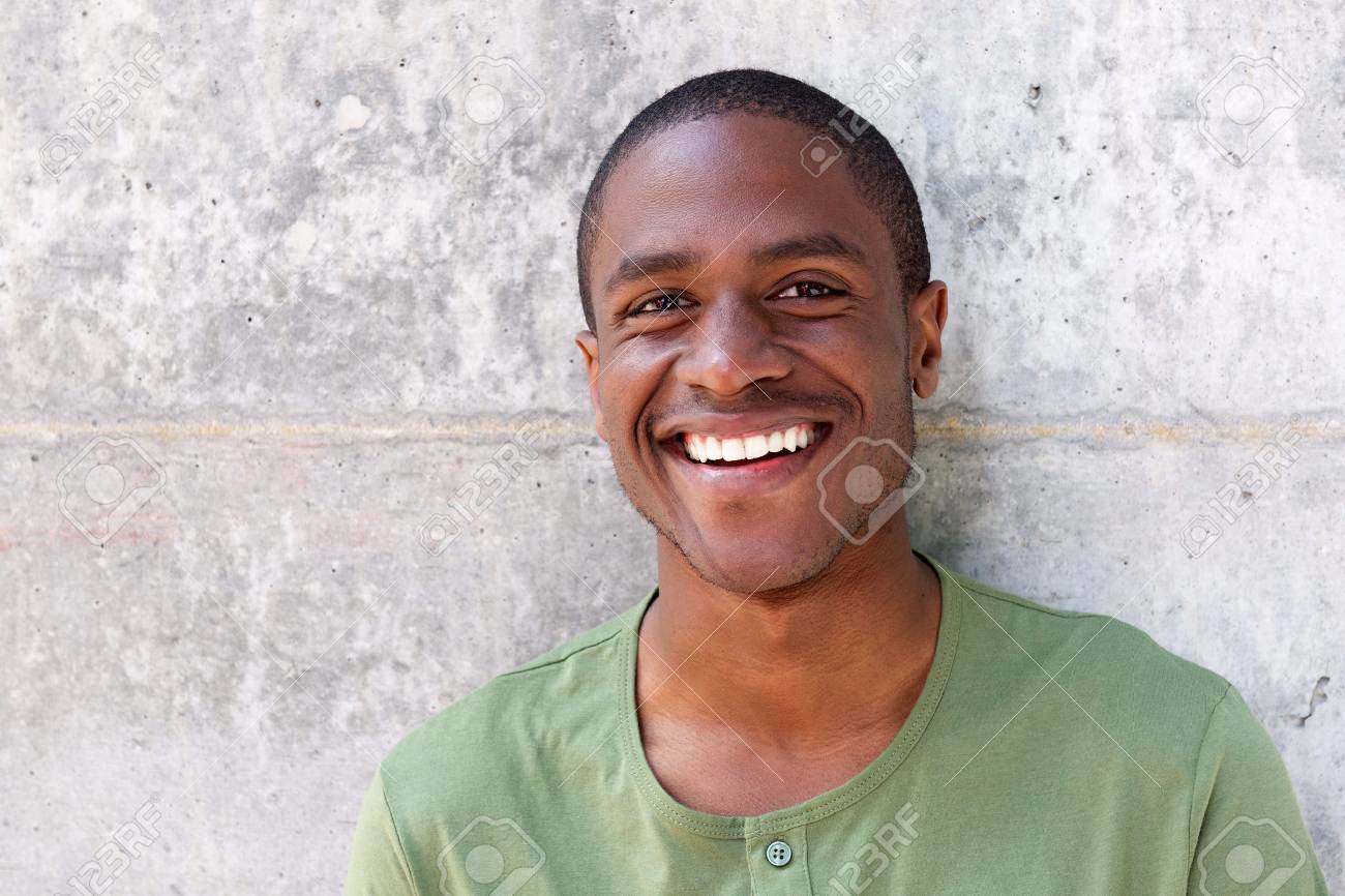 Close up portrait of cheerful young black man smiling against wall - 67048334 Close up portrait of cheerful young black man smiling against wall - 67048334