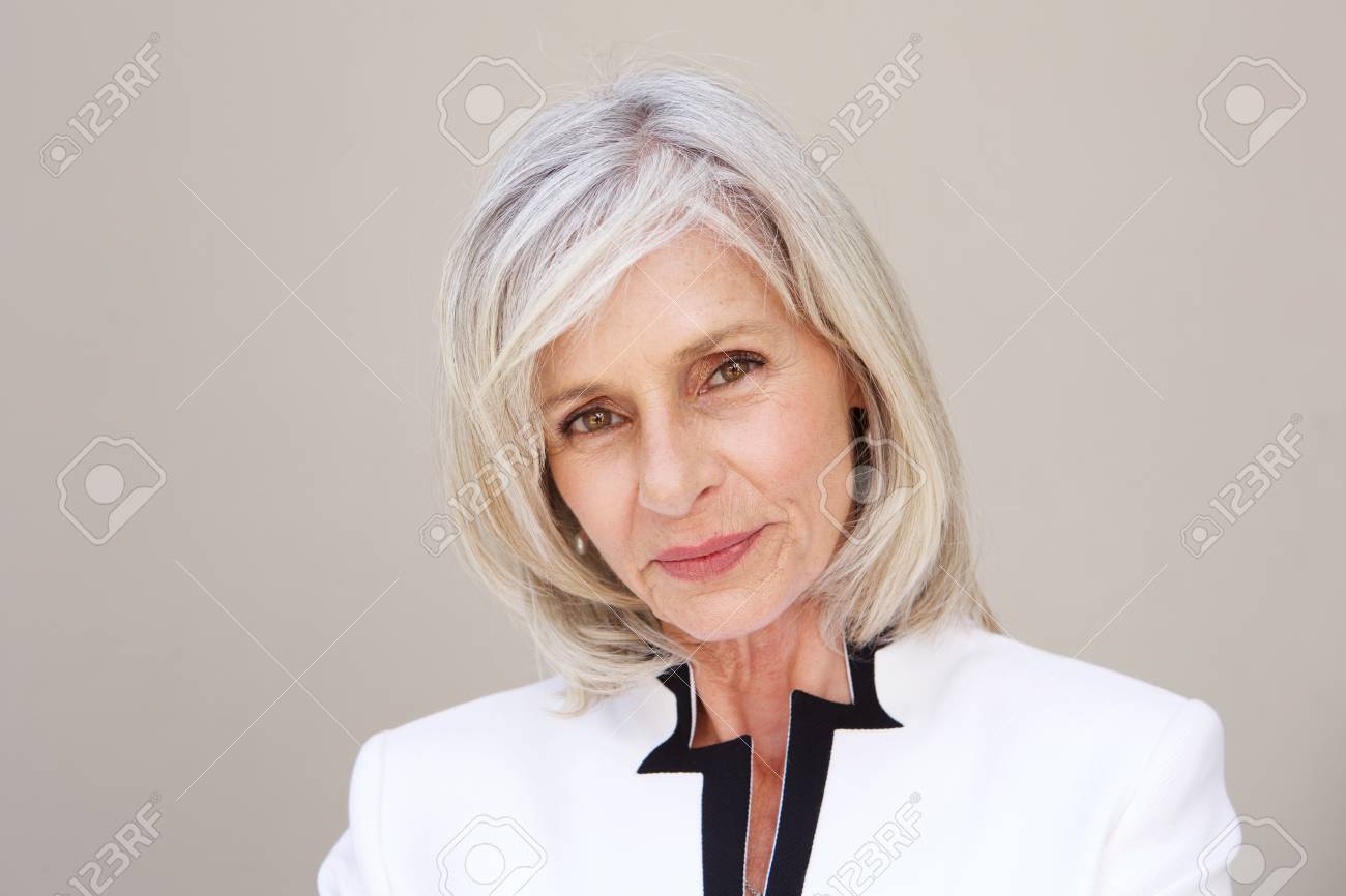 Close up portrait of beautiful older woman staring standing by wall - 74022131 Close up portrait of beautiful older woman staring standing by wall - 74022131