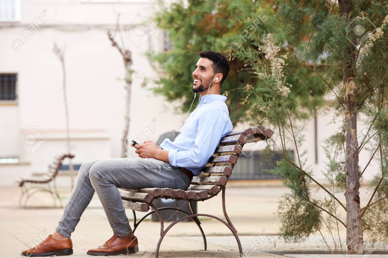 携帯電話で音楽を聴いてベンチに座っている幸せなアラビア人男性の肖像画 の写真素材 画像素材 Image 携帯電話で音楽を聴いてベンチに座っている幸せなアラビア人男性の肖像画 の写真素材 画像素材 Image