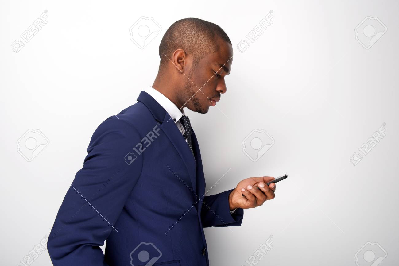 Side portrait of young black businessman looking at mobile phone - 118849673 Side portrait of young black businessman looking at mobile phone - 118849673