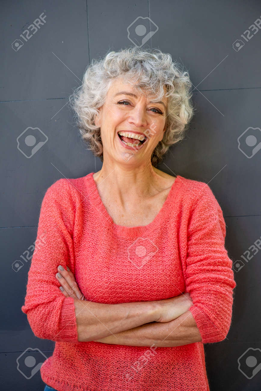 Front portrait of attractive middle aged woman laughing with arms crossed - 133515654 Front portrait of attractive middle aged woman laughing with arms crossed - 133515654