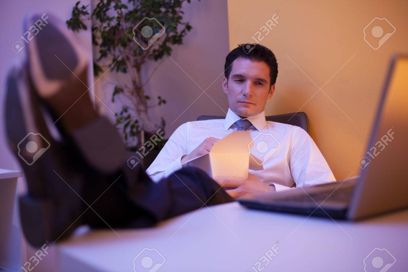tired businessman trying to stay awake while eating chinese food trying to stay awake
