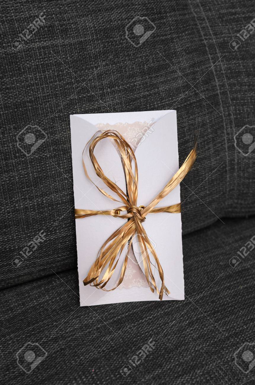 wedding invitations handmade with a golden ribbon on a gray background ribbon for invitations