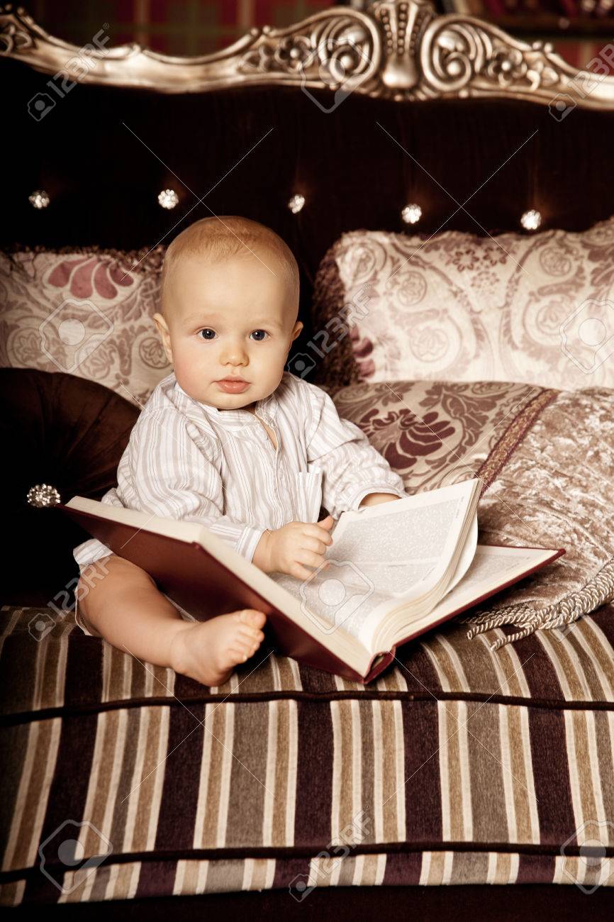 Beaute Petit Enfant A L Interieur De Lire Un Livre Sourire Bebe Dans La Chambre En Lisant Un Livre Bebe Sur Le Divan Banque D Images Et Photos Libres De Droits Image