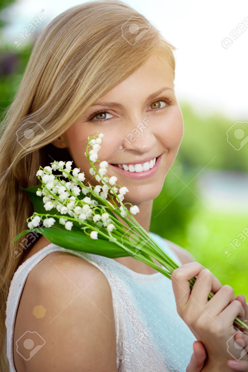 Young woman with a beautiful smile with healthy teeth with flowers. - 58593161 Young woman with a beautiful smile with healthy teeth with flowers. - 58593161