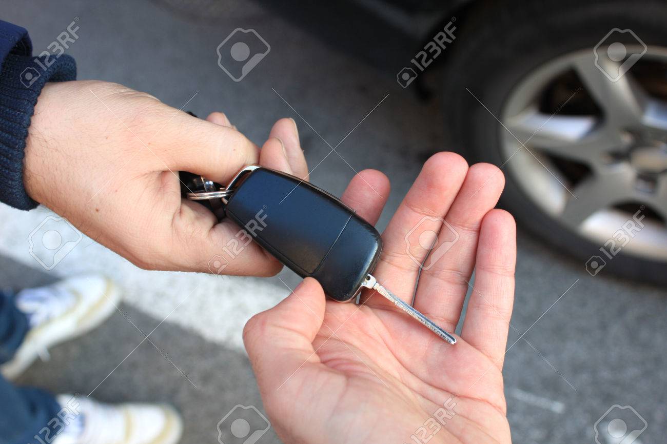 one person sells car and gives the key to the new owner - 54698198 one person sells car and gives the key to the new owner - 54698198