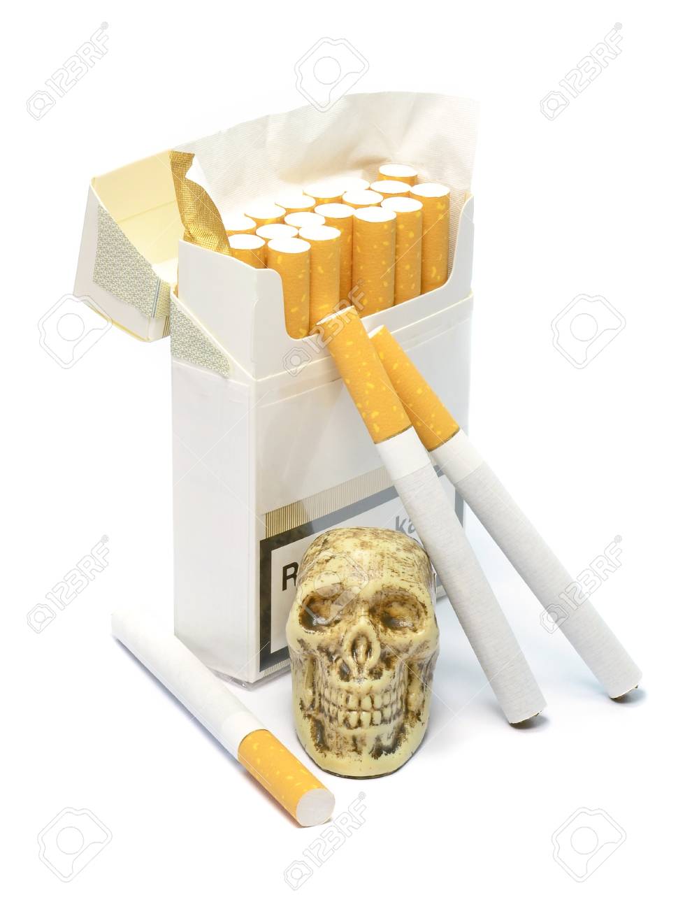 smoking kills concept with skull sitting next to a box of cigarettes box of cigarette