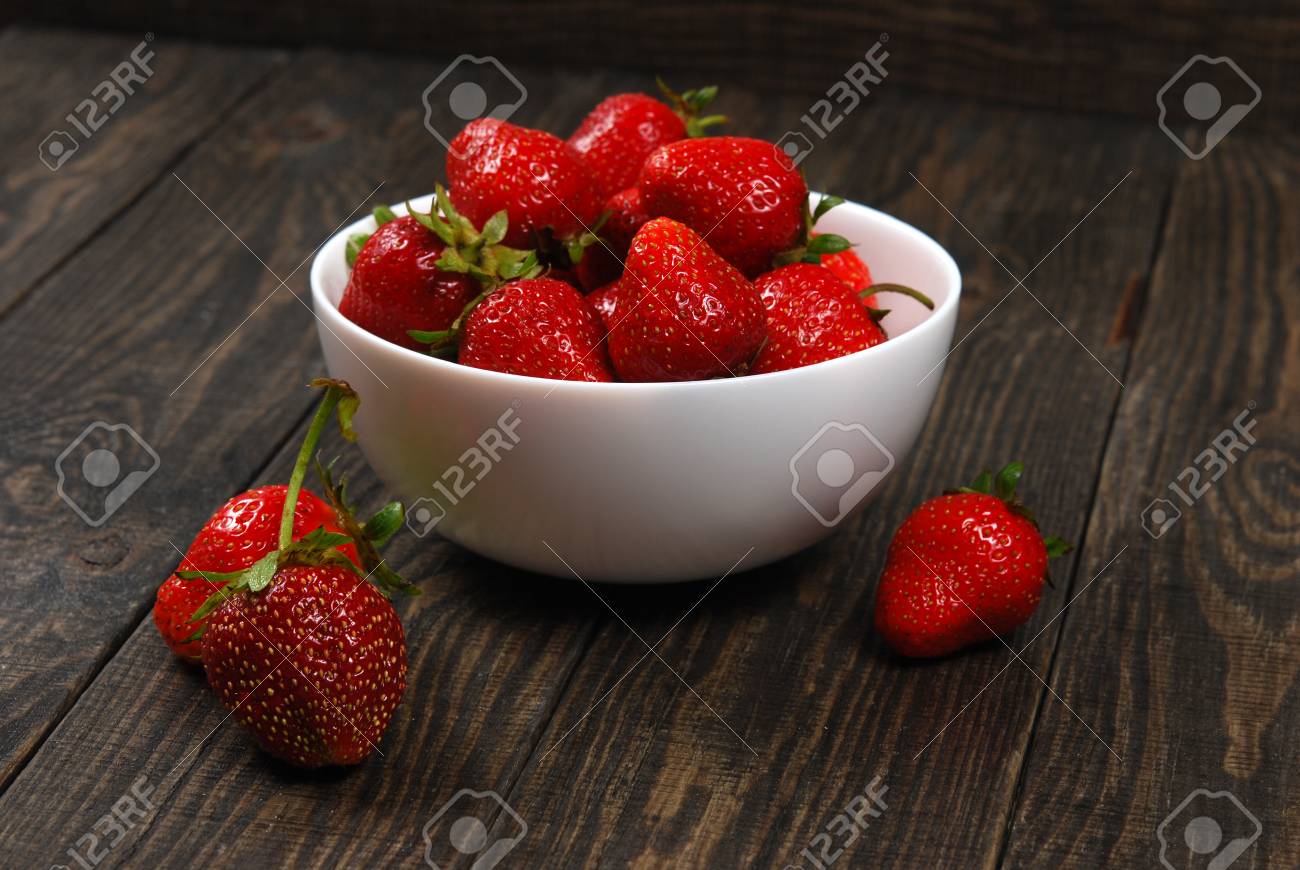 Lein-Wand-Bild Essensbilder Früchte Erdbeeren in weißer Schale auf dunklem Holz