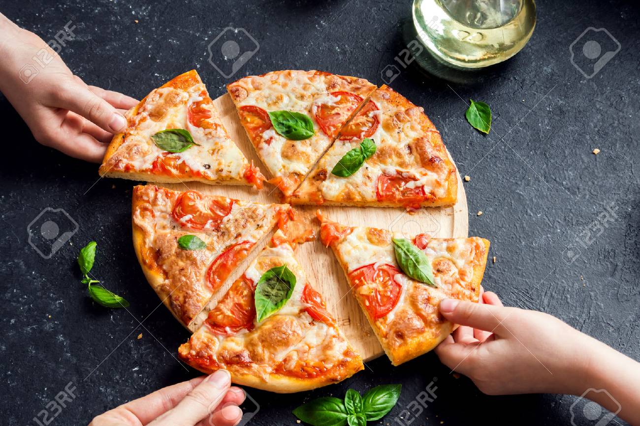 マルゲリータ ピザのスライスをとる人々 の手 ピザ マルガリータと手は黒の背景をかけて閉めます の写真素材 画像素材 Image