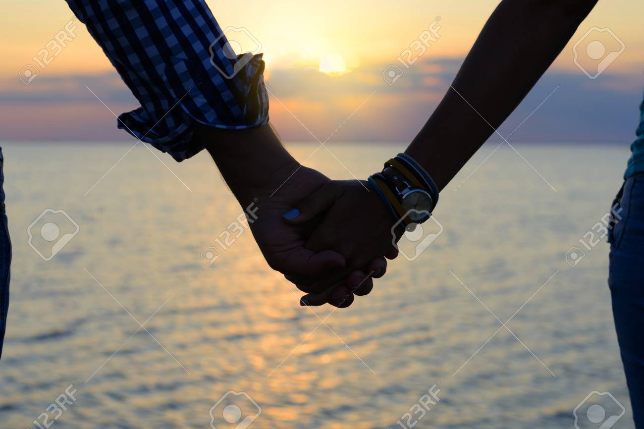 愛するカップル 男と女の子のシルエット は 桟橋で海に夕日の光線で手を握る の写真素材 画像素材 Image