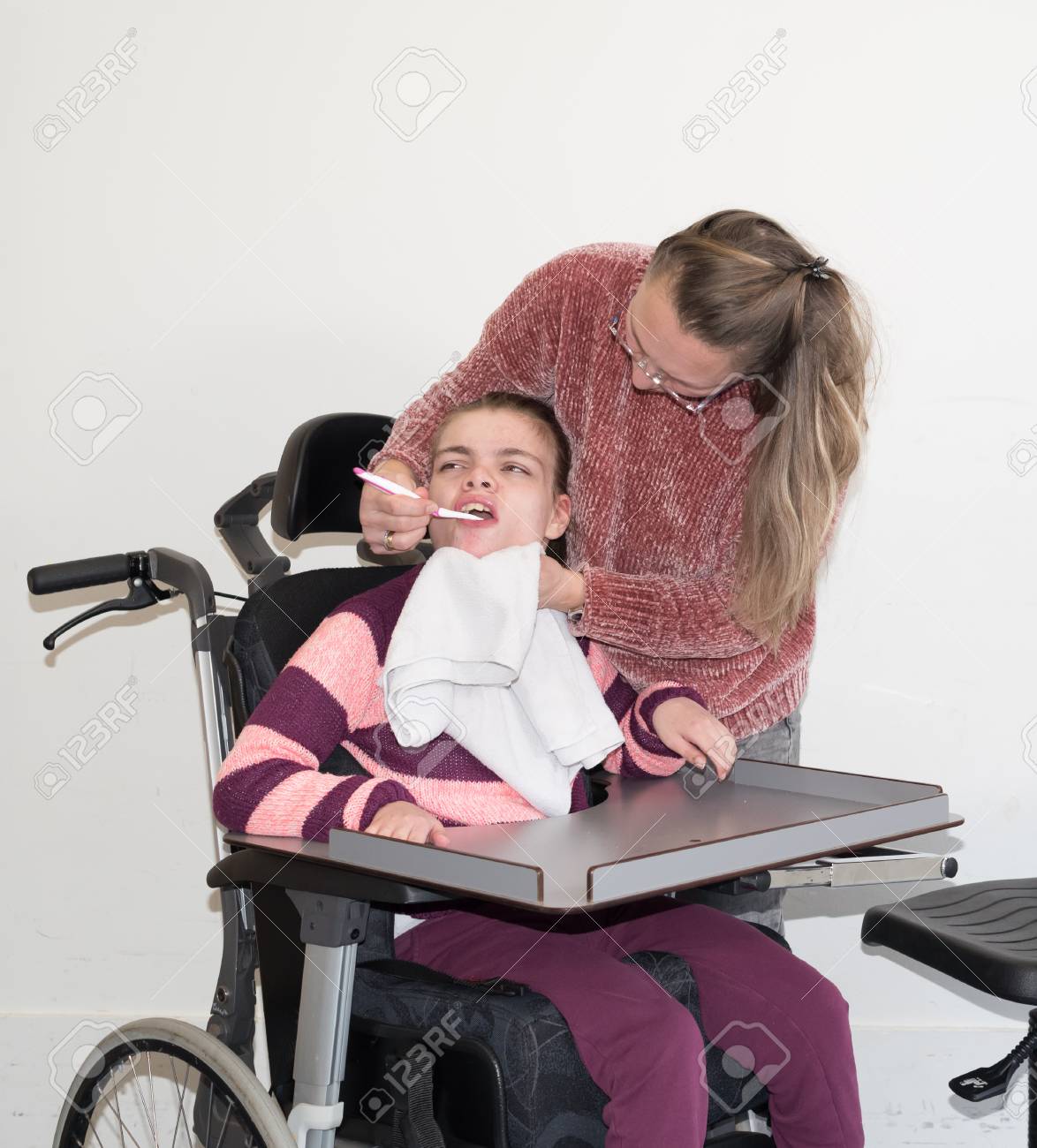 自発的な介護従事者と一緒に車椅子の障害児 の写真素材 画像素材 Image