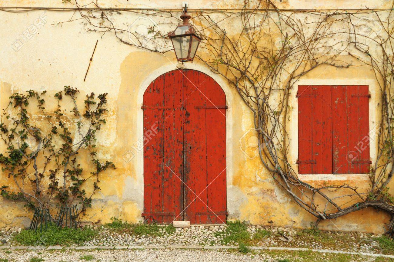 Exterior of yellow painted Tuscan villa with white shutters on half-glazed  double doors Stock Photo - Alamy