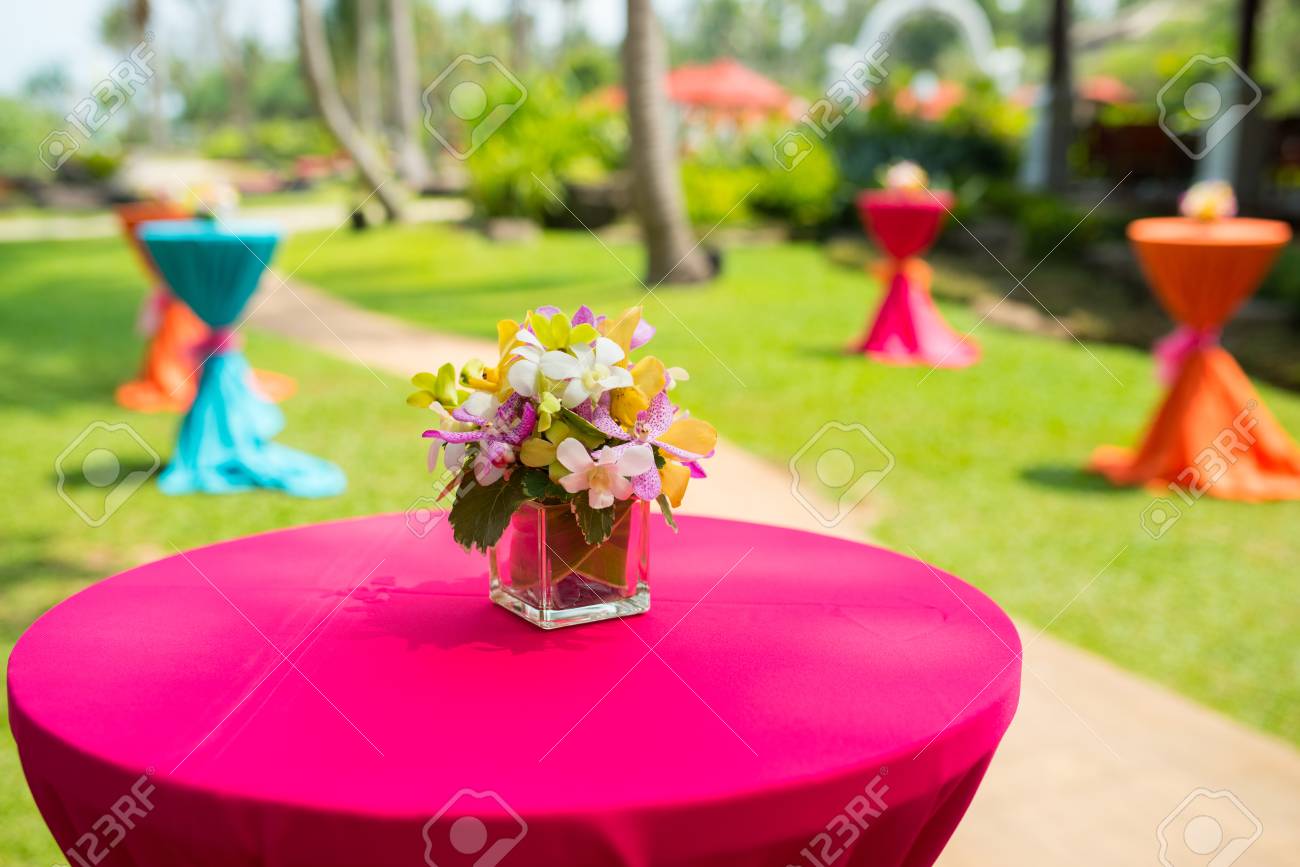 colorful orchid in glass jar on bar desk with vivid desk cover