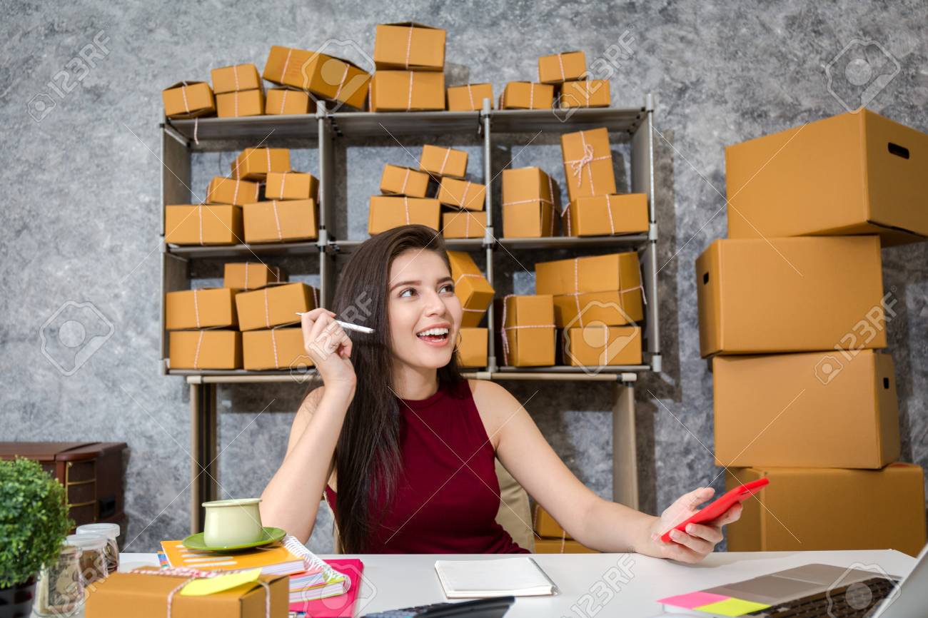 Young business owner as online freelancer checking the box and check the customer list. - 93143452 Young business owner as online freelancer checking the box and check the customer list. - 93143452