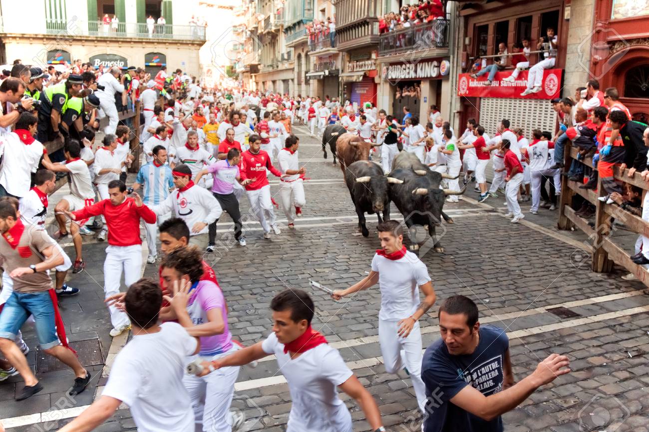 PAMPLONA, SPAIN -JULY 14: Unidentified men run from bulls in street Estafeta during San Fermin festival in Pamplona, Spain on July 14, 2013. - 23383543 PAMPLONA, SPAIN -JULY 14: Unidentified men run from bulls in street Estafeta during San Fermin festival in Pamplona, Spain on July 14, 2013. - 23383543
