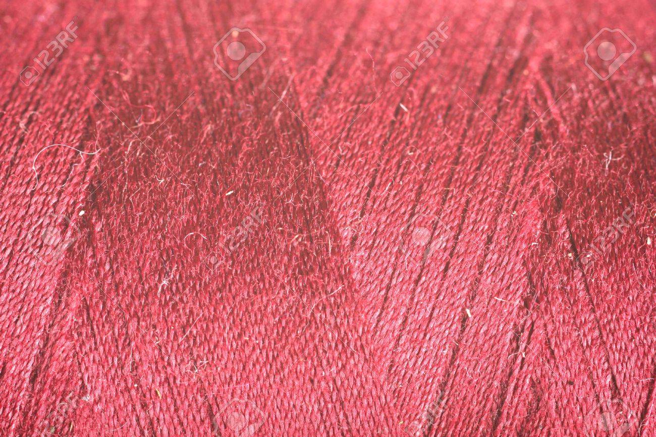 orange red thread fabric wool yarn wrapped in a spool of threads