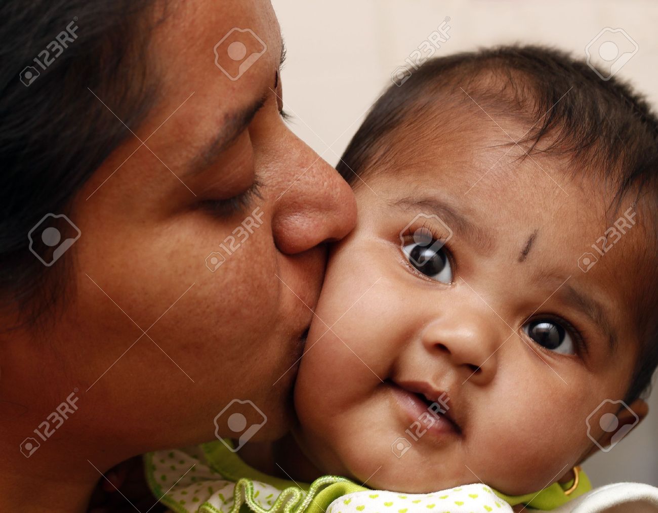 写真は彼女のミイラと笑みを浮かべて女性のインドの子供子供のキスで娘に母を表現する愛愛情を込めて 幼児を包含し 彼女にキス の写真素材 画像素材 Image