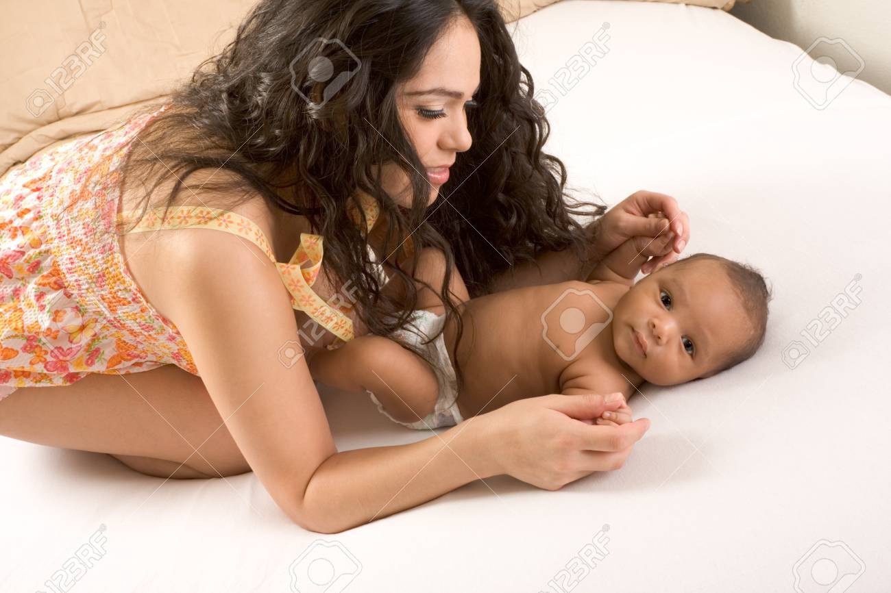 Hispanic Mom Lying Down On Bed And Holding Her Biracial Mix Of Hispanic And  African American Infant Son (baby Is 7 Weeks Old) Stock Photo, Picture and  Royalty Free Image. Image 9165205., image size:1300x866