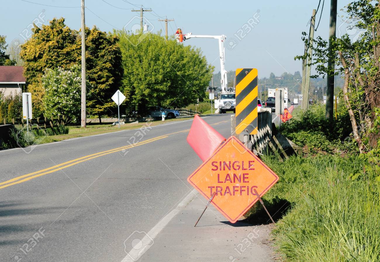 a hydro crew works on a public road with signs and flags used crew works