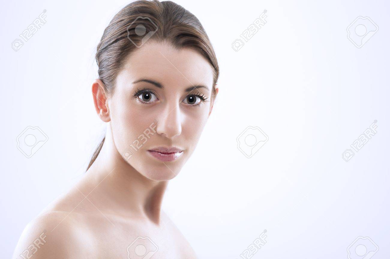 大規模な光沢の有る眼を持つカメラを見てポニーテールで結ばれる裸の肩 自然な顔色と彼女の髪の美しいセクシーな女性の頭と肩のスタジオ ポートレート の写真素材 画像素材 Image