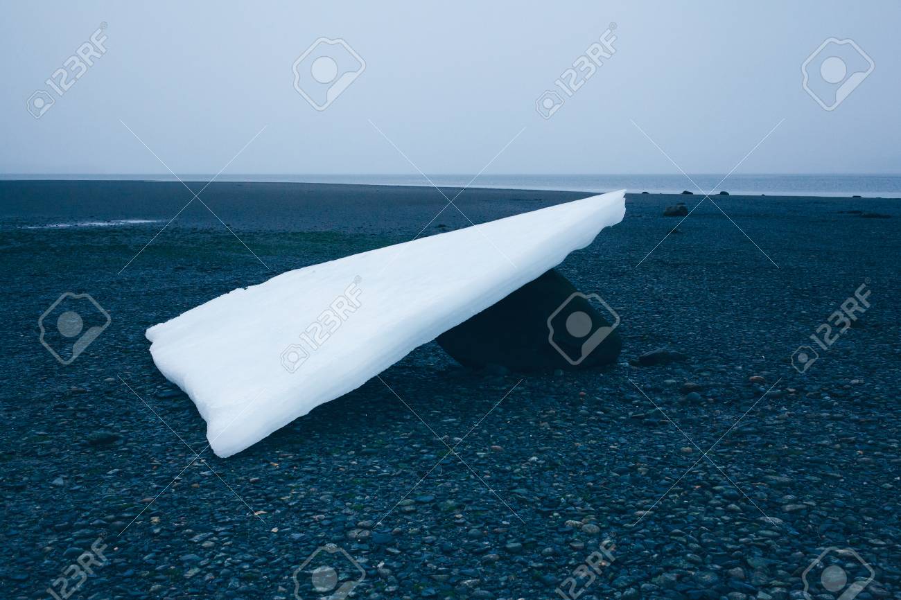 大きな岩で休む干潮で明らかに遠くのアラスカ海岸の氷 の写真素材 画像素材 Image