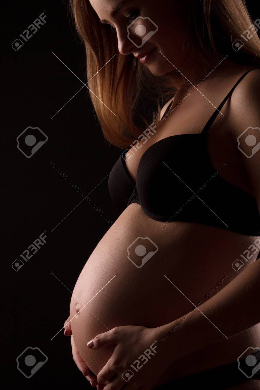 Immagini Stock - Giovane Donna Incinta In Intimo Nero È Abbracciare La Sua  Pancia Su Sfondo Nero. Image 55151379