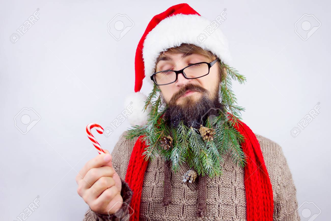 クリスマスのお菓子を見て眼鏡をかけてサンタとクリスマス ツリーとコーン 緑の枝で飾られたひげとして服を着た男 の写真素材 画像素材 Image