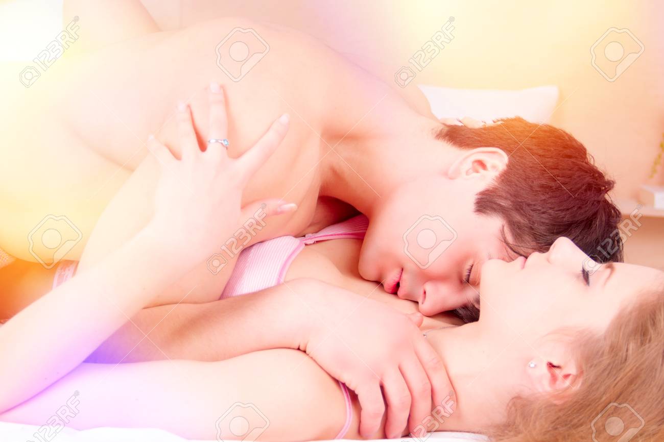 Cerca De La Pareja De Besos En El Amor En Ropa Interior Rosada La Cama Por La Mañana Fotos, Retratos, Imágenes Y Fotografía De Archivo Libres De Derecho. Image 89947183.