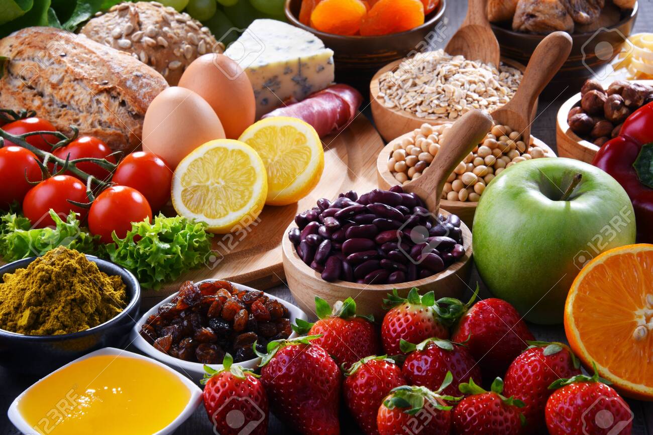 Composition with assorted organic food products on wooden kitchen table. - 121461006 Composition with assorted organic food products on wooden kitchen table. - 121461006