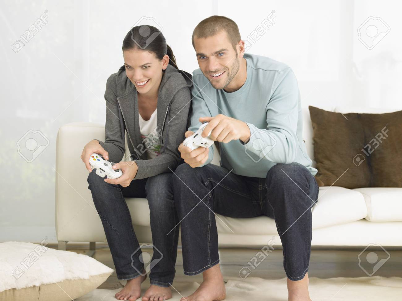 Pareja En El Sofa Que Juega Al Juego Video Fotos Retratos Imagenes Y Fotografia De Archivo Libres De Derecho Image 19184635
