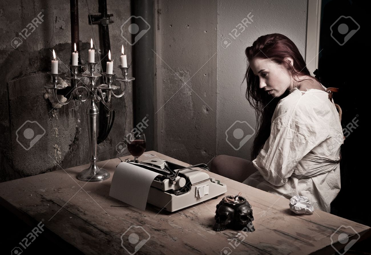a mad girl wearing a straight jacket in front of a typewriter stock