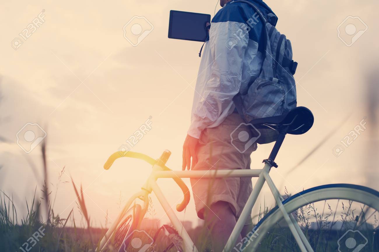 Junger Mann Mit Fahrrad Im Grunen Feld Fotografieren Mit Tablet Computer Vorsatzliche Sonneneinstrahlung Und Vintage Farben Fokus Auf Mann Lizenzfreie Fotos Bilder Und Stock Fotografie Image