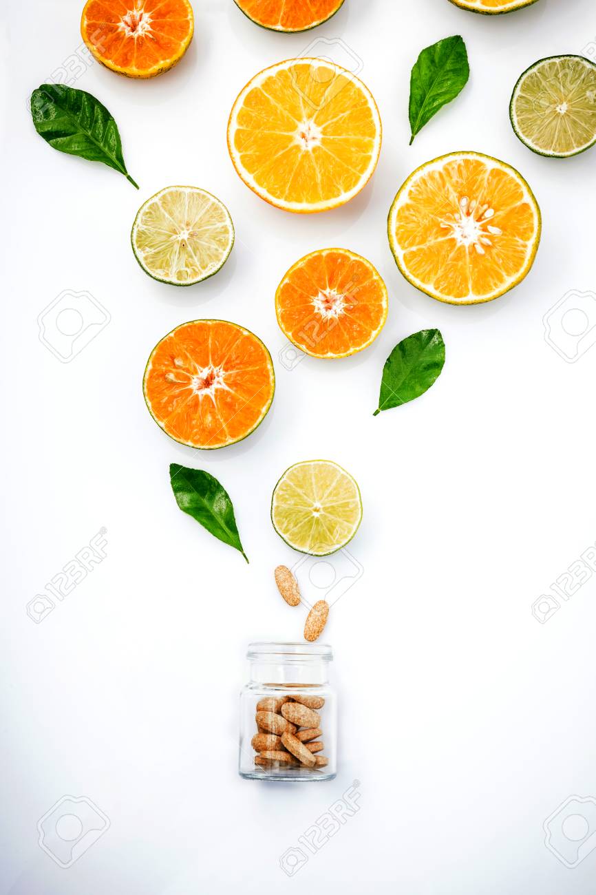 柑橘系の果物 オレンジ ライム レモン 白い背景の上のガラス瓶の中のビタミン C のタブレットをカットのカラフルです 果物からビタミン C Extract ビタミン C の概念 栄養補助健康食品 の写真素材 画像素材 Image