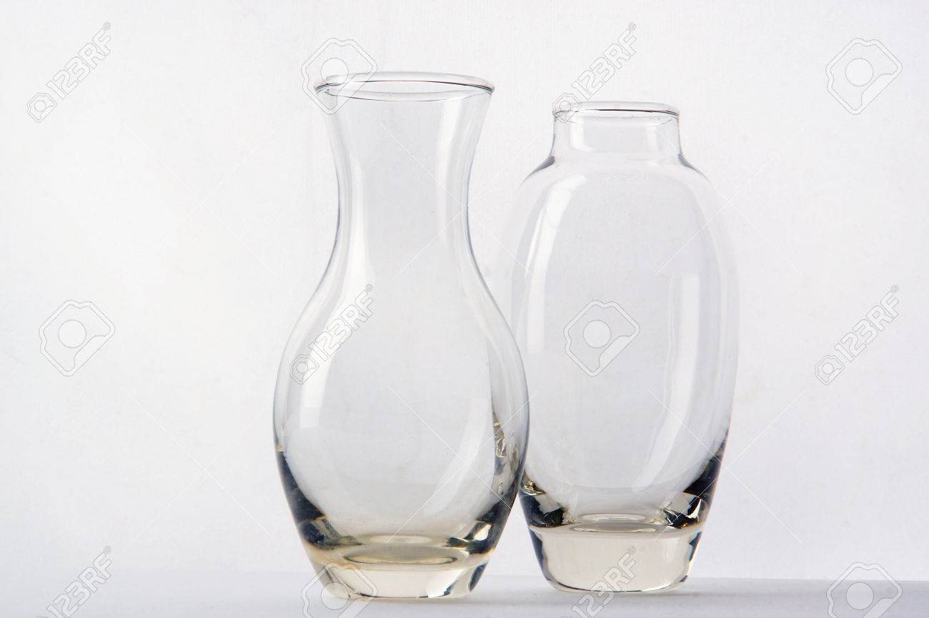 Two Glass Vases Of Different Shapes Are Side By Side On A White